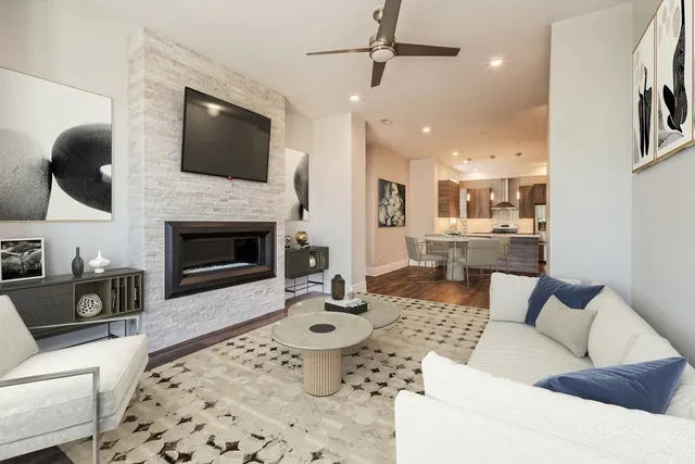 a living room with furniture a flat screen tv and a fireplace