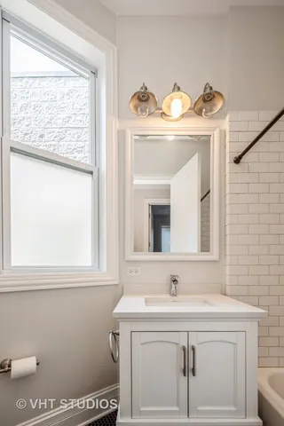 a bathroom with a sink a mirror and a window