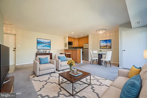 a living room with furniture and kitchen view