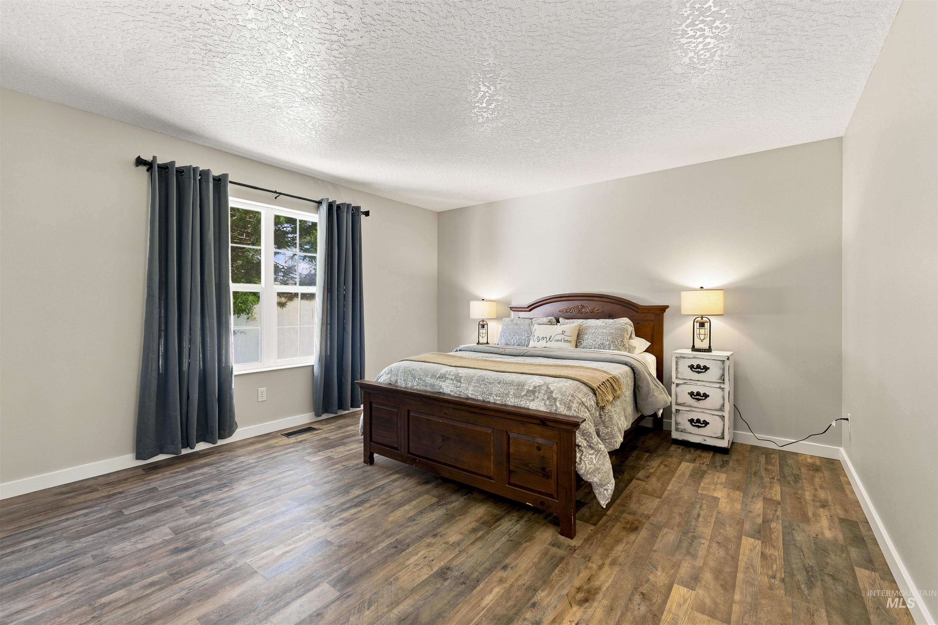 24864 Coventry Drive Caldwell, ID 83607 - Photo 24 of 49 Spacious room featuring wood-finish flooring, light neutral wall paint, and a large window with white trim