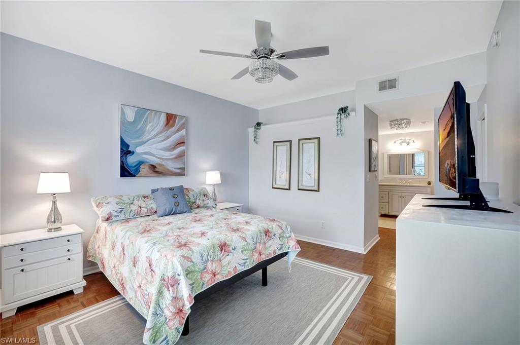 613 Windsor Square, Unit 101 Naples, FL 34104 - Photo 11 of 22 a bedroom with a bed and a flat screen tv