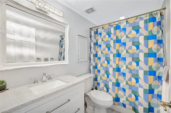 a bathroom with a granite countertop sink a toilet and a mirror