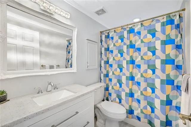 a bathroom with a granite countertop sink a toilet and a mirror