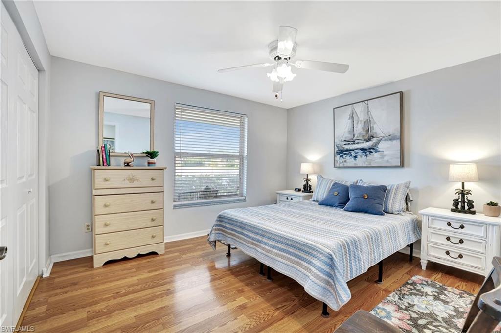 613 Windsor Square, Unit 101 Naples, FL 34104 - Photo 13 of 22 a bedroom with a bed and a chandelier