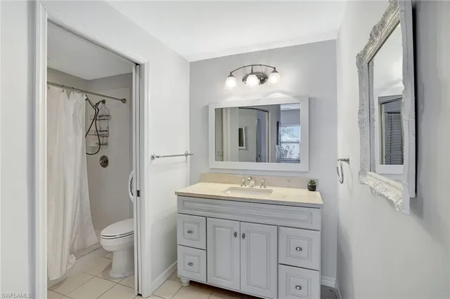 a bathroom with a toilet sink double vanity and mirror