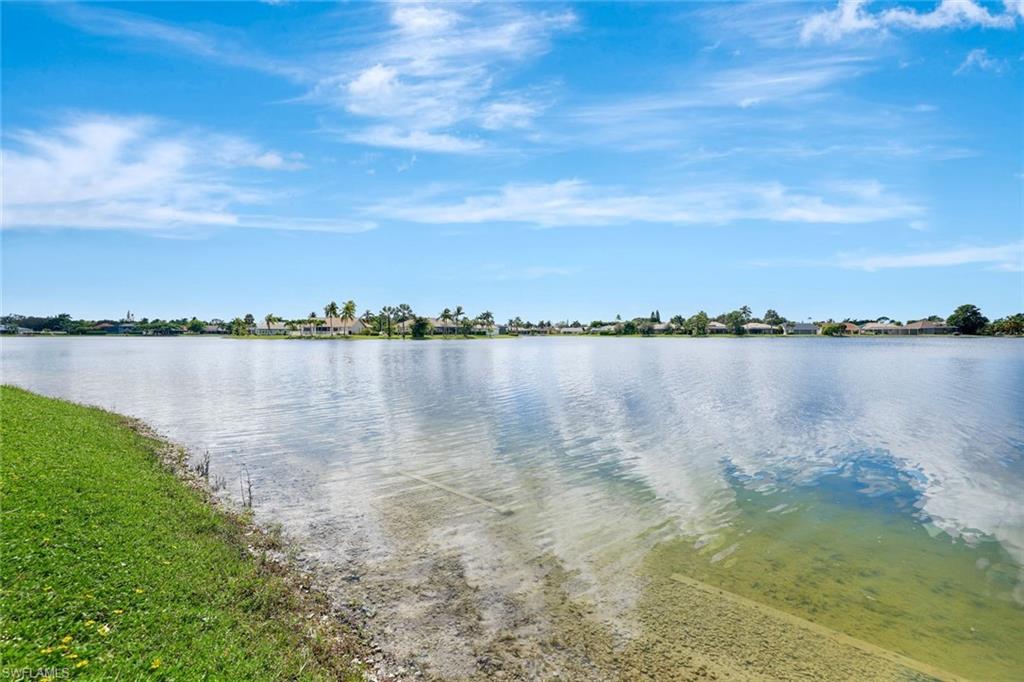613 Windsor Square, Unit 101 Naples, FL 34104 - Photo 16 of 22 a view of a lake with houses in the back