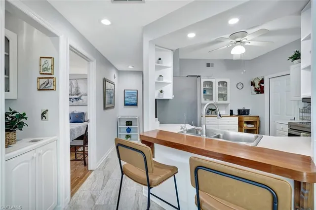 a room with stainless steel appliances kitchen island granite countertop a refrigerator and cabinets