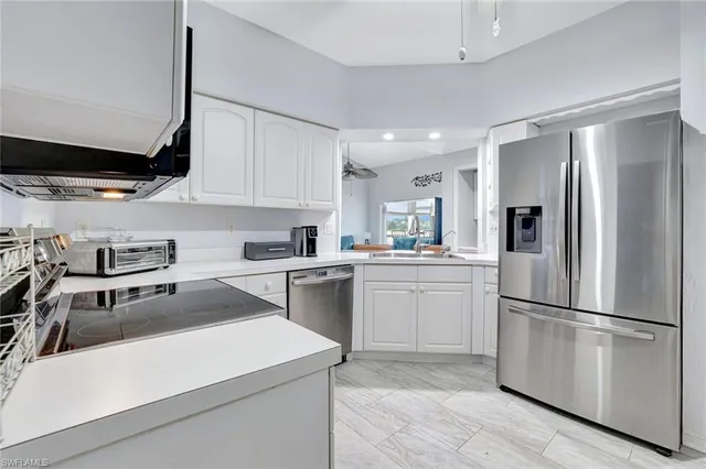 a kitchen with a refrigerator a sink and cabinets