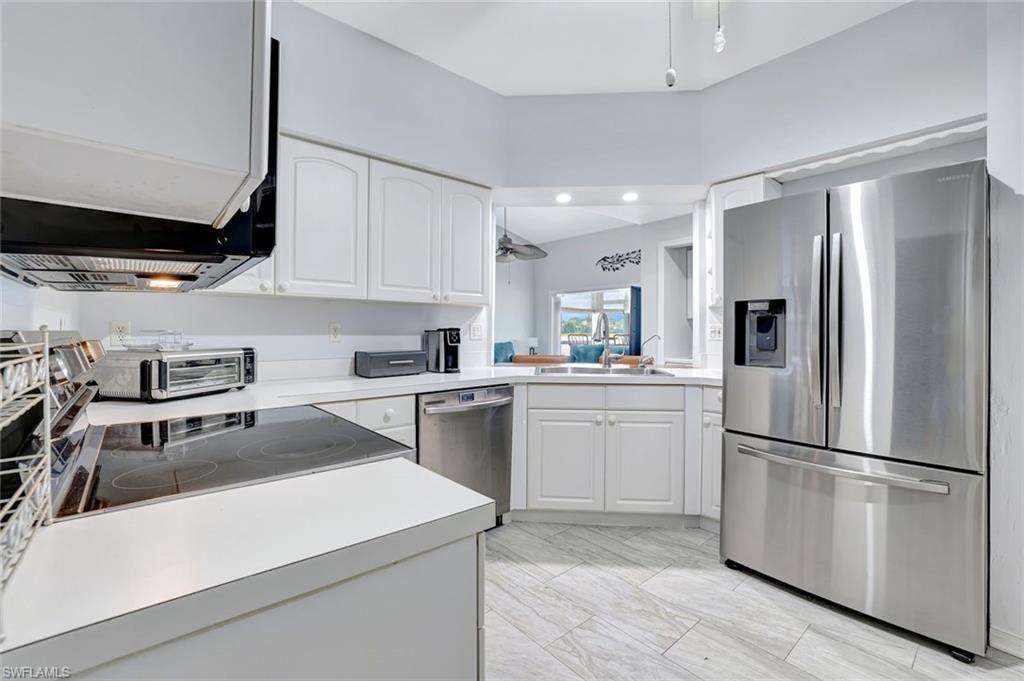 613 Windsor Square, Unit 101 Naples, FL 34104 - Photo 5 of 22 a kitchen with a refrigerator a sink and cabinets