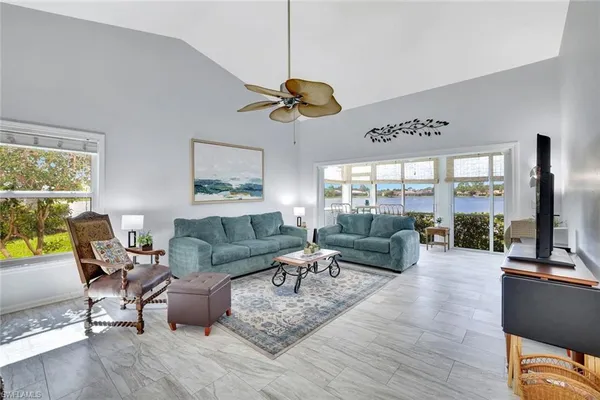 a living room with furniture a flat screen tv and a large window