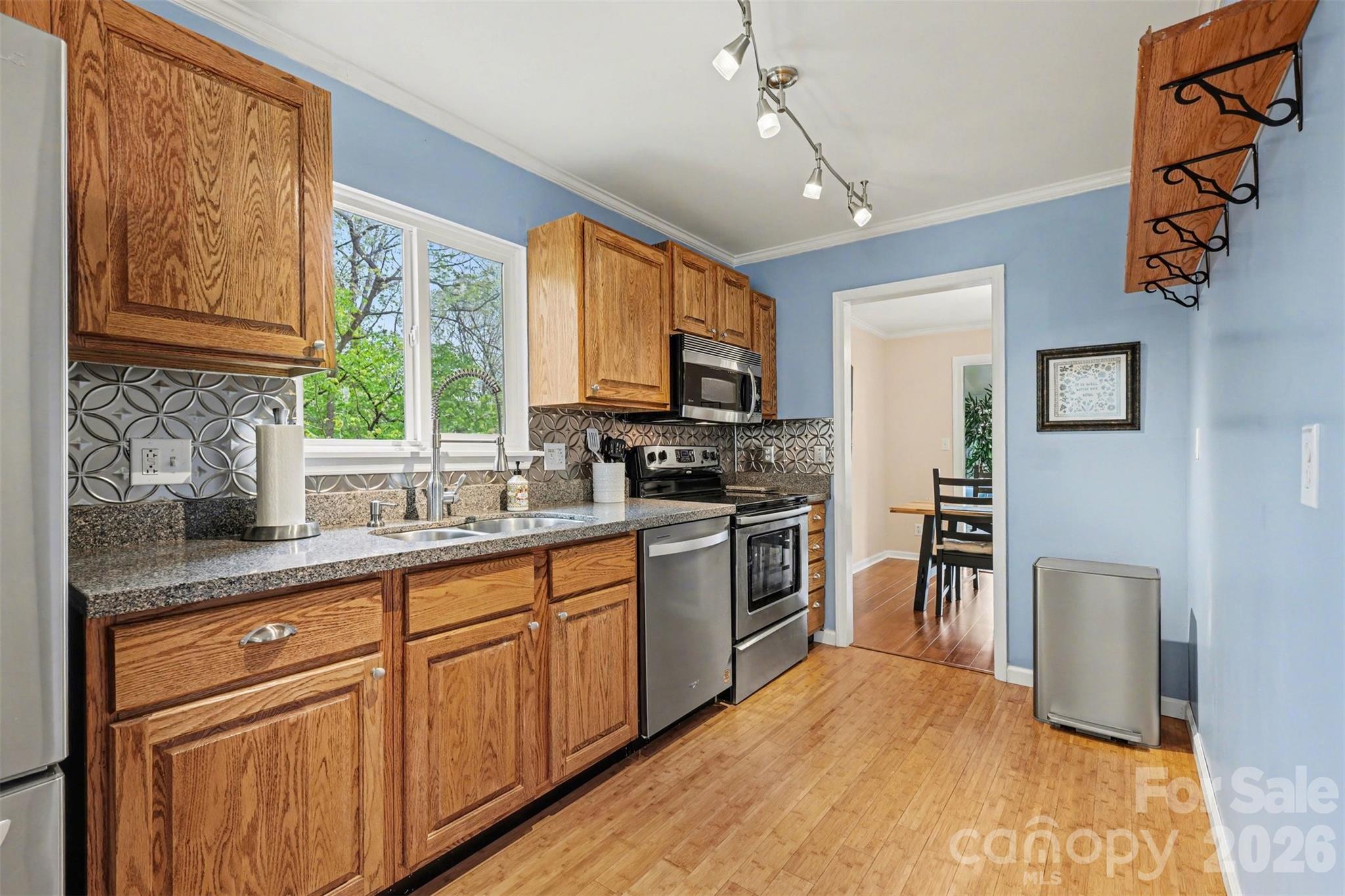 26030 Misty Way Drive Tega Cay, SC 29708 - Photo 10 of 43 a kitchen with granite countertop a stove a sink dishwasher and a refrigerator with wooden floor