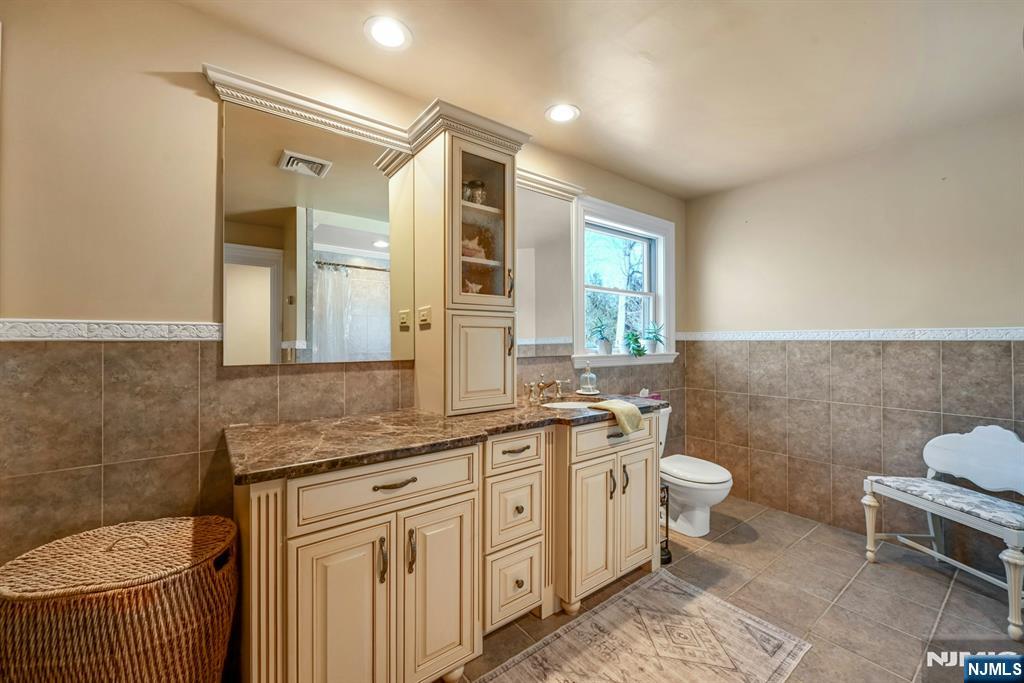 285 Chestnut Ridge Road Woodcliff Lake, NJ 07677 - Photo 32 of 46 a bathroom with a sink toilet a mirror and vanity