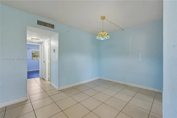 a view of a livingroom with a chandelier fan and wooden floor
