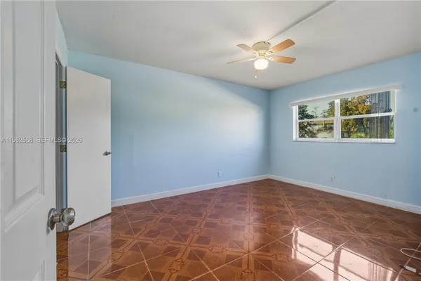 an empty room with windows and ceiling fan