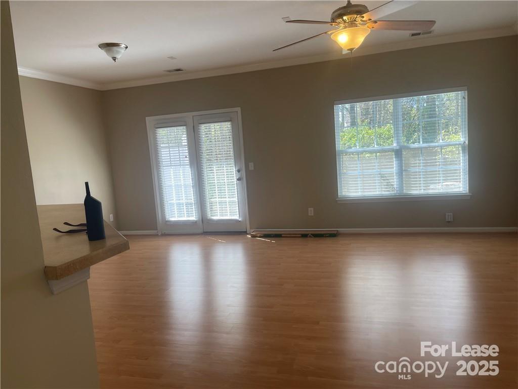 11917 Stratfield Pl Circle, Unit 118 Pineville, NC 28134 - Photo 14 of 28 an empty room with wooden floor and windows