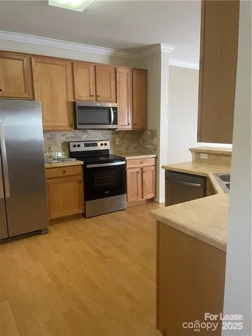 a kitchen with granite countertop a sink a stove top oven and refrigerator