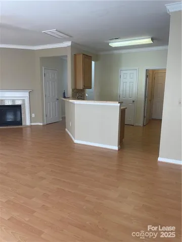 a view of a hallway with wooden floor and a living room