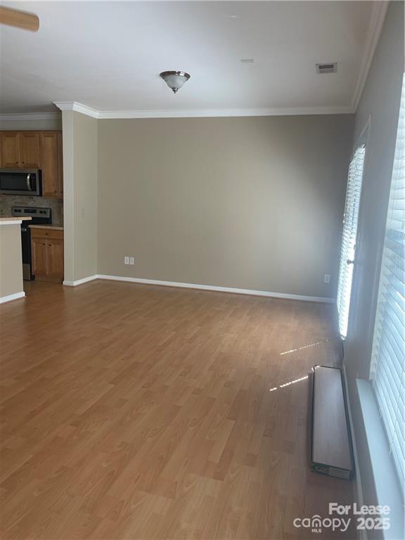 11917 Stratfield Pl Circle, Unit 118 Pineville, NC 28134 - Photo 10 of 28 a view of an empty room with wooden floor and a window