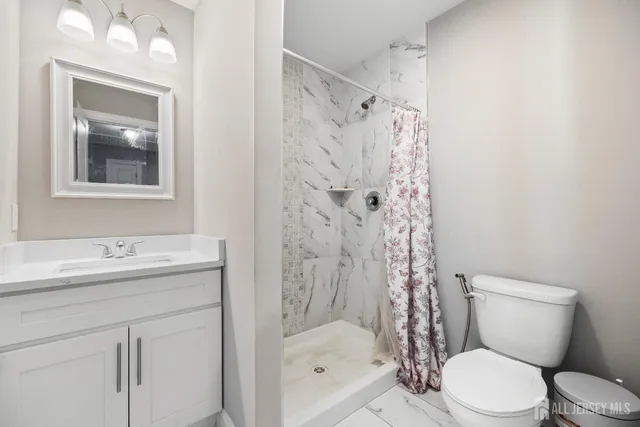 a bathroom with a shower toilet sink and mirror