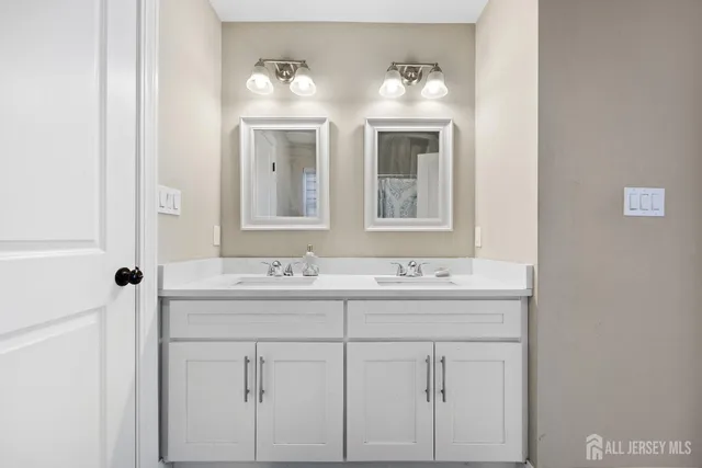 a bathroom with double sink and a mirror