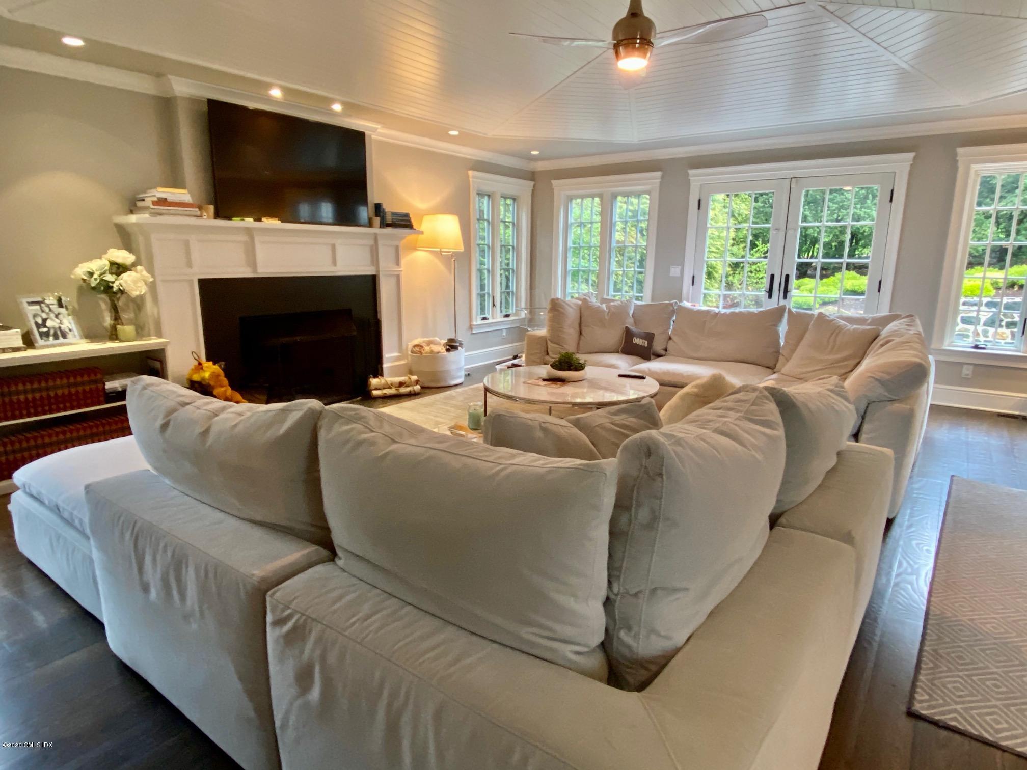 1 Club Road Riverside, CT 06878 - Photo 11 of 37 a living room with fireplace furniture a flat screen tv and a large window