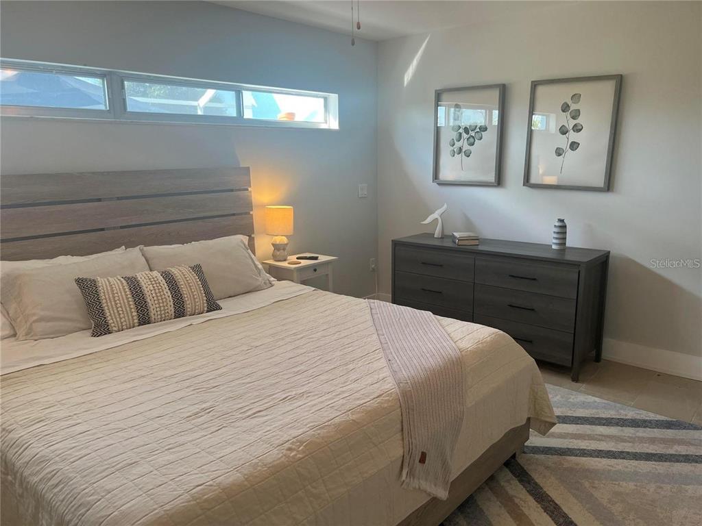 118 Caddy Road Rotonda West, FL 33947 - Photo 7 of 10 a bedroom with a bed and painting on the wall