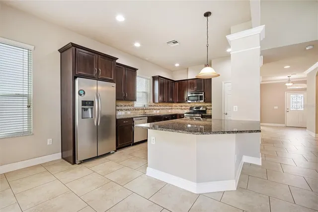 a kitchen with stainless steel appliances granite countertop a refrigerator a sink and a stove