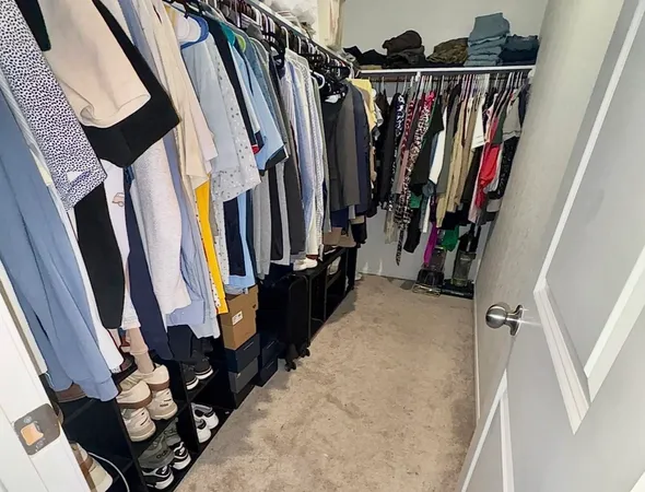 a view of walk in closet with clothes and shoes