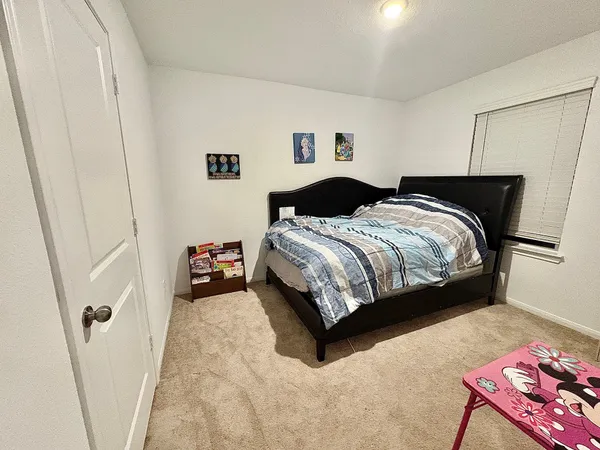 a bedroom with a bed and a window