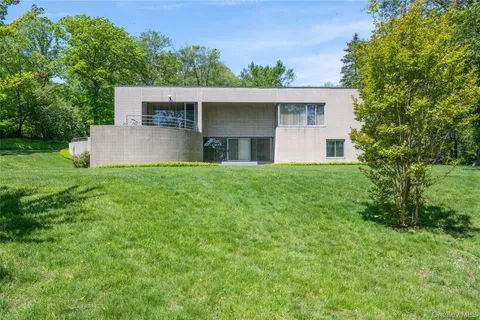 a front view of a house with a yard and trees