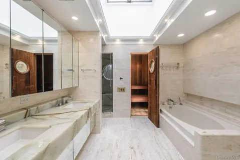 a spacious bathroom with a tub sink shower and mirror