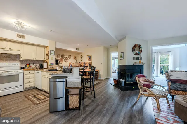 a kitchen with white cabinets and chairs