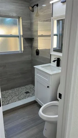 a bathroom with a sink a toilet and window