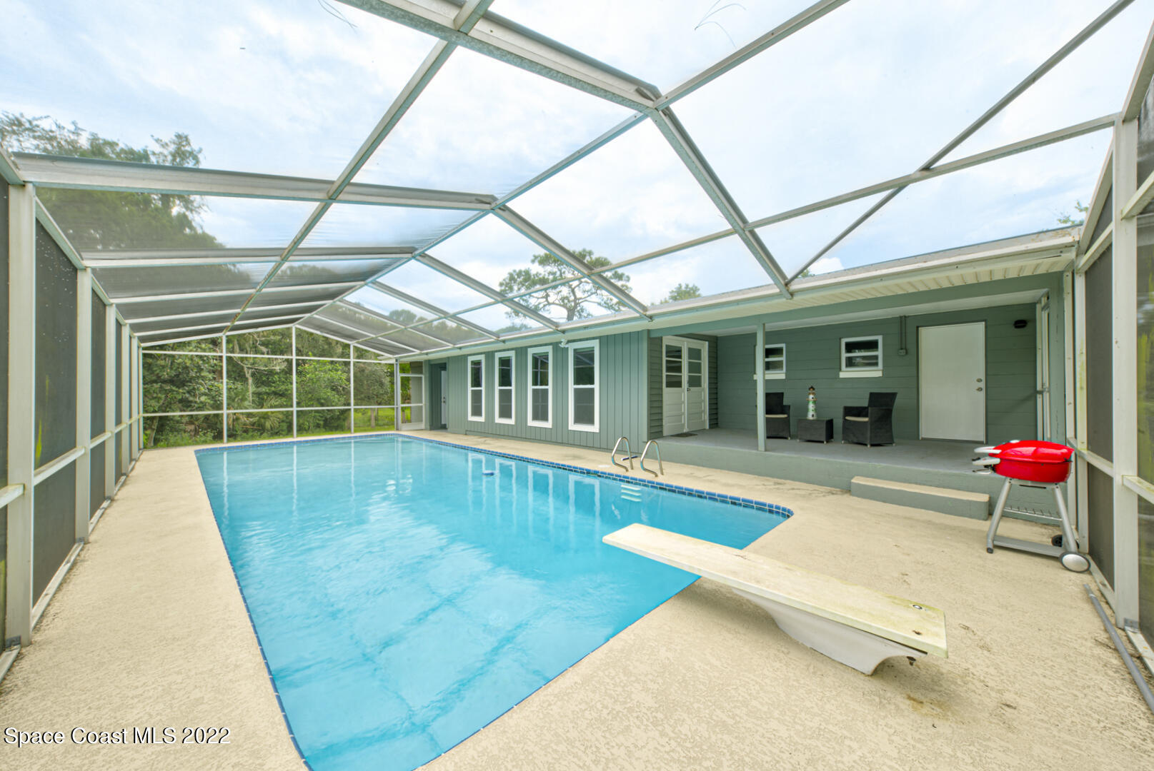 a view of swimming pool with a patio and yard of the house