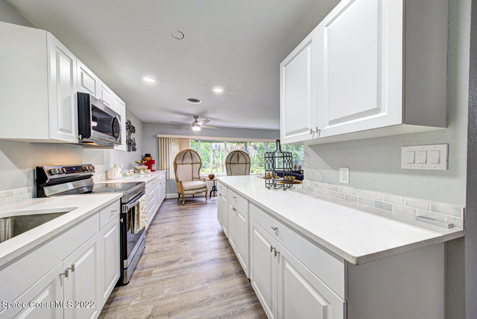 758 Buffalo Road Titusville, FL 32796 - Photo 17 of 52 a kitchen that has a lot of white cabinets and wooden floor