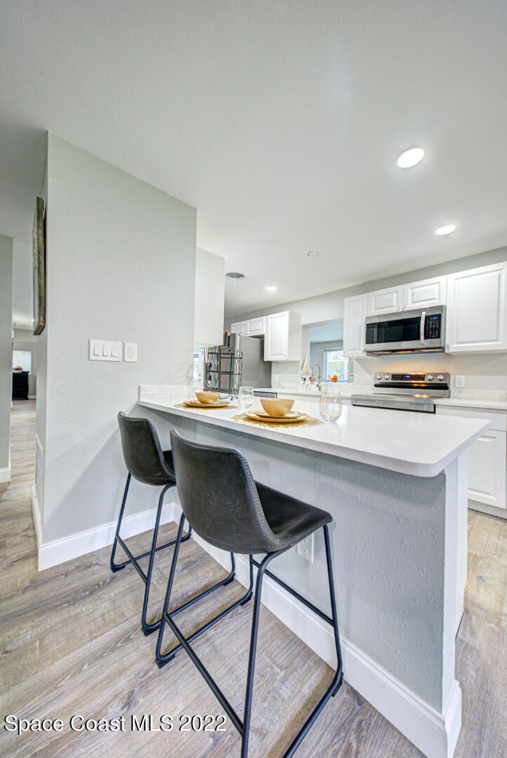 758 Buffalo Road Titusville, FL 32796 - Photo 20 of 52 a kitchen with a dining table chairs and a refrigerator