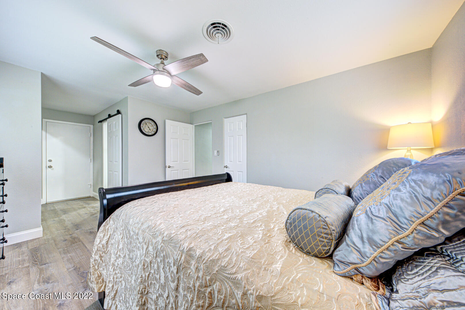 758 Buffalo Road Titusville, FL 32796 - Photo 25 of 52 a bedroom with a large bed and a chandelier