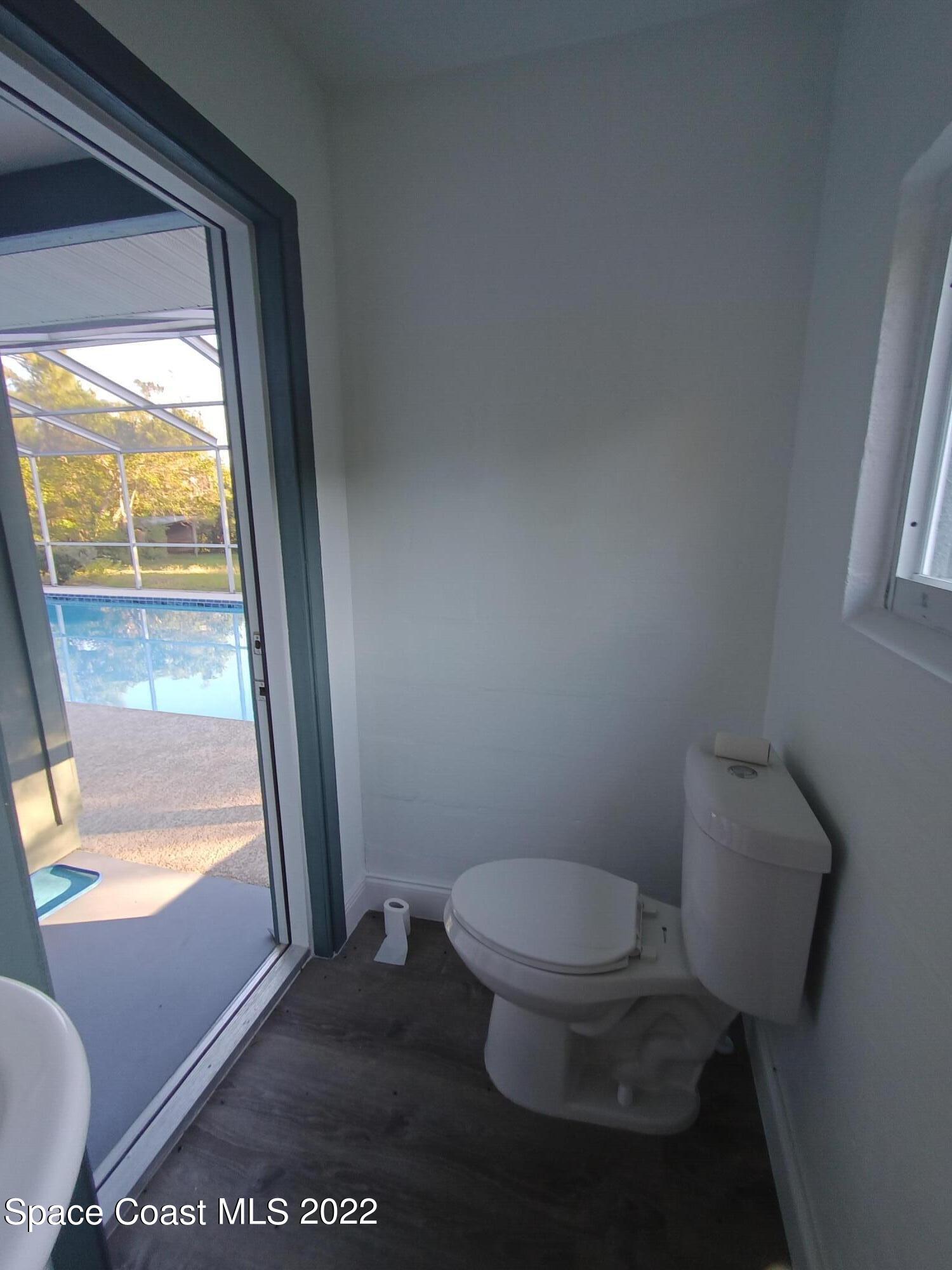 758 Buffalo Road Titusville, FL 32796 - Photo 44 of 52 a toilet sitting in a bathroom next to a window