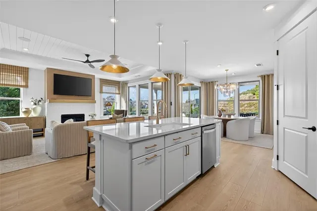 a kitchen with sink stove and white cabinets with wooden floor