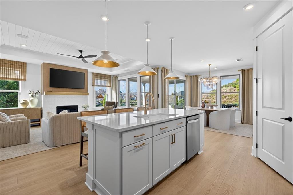 5425 Cordina Road Hoschton, GA 30548 - Photo 12 of 30 a kitchen with sink stove and white cabinets with wooden floor