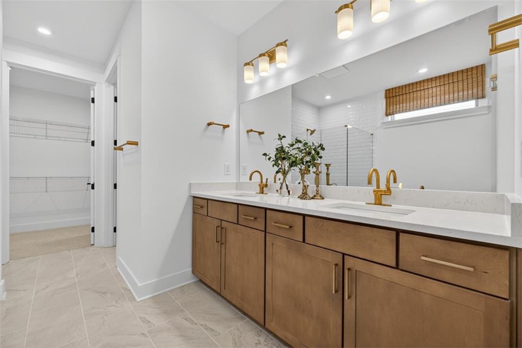 5425 Cordina Road Hoschton, GA 30548 - Photo 20 of 30 a bathroom with a sink a mirror and a shower