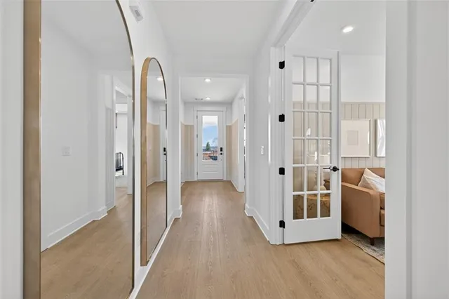 a view of a hallway with wooden floor and cabinet