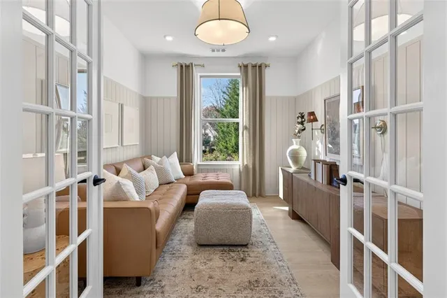 a living room with furniture large window and wooden floor