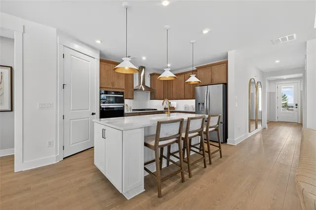 a kitchen with stainless steel appliances kitchen island a refrigerator and a wooden cabinets