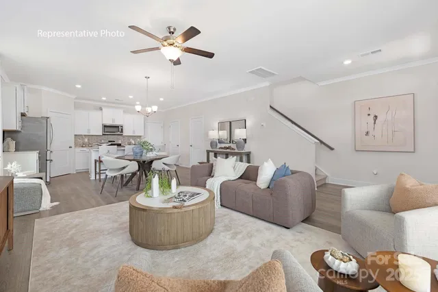 a living room with furniture and a view of kitchen