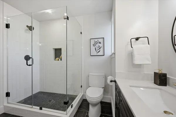 a bathroom with a sink a toilet a shower and a mirror