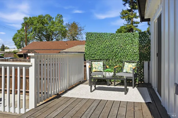 a balcony with wooden floor table and chairs