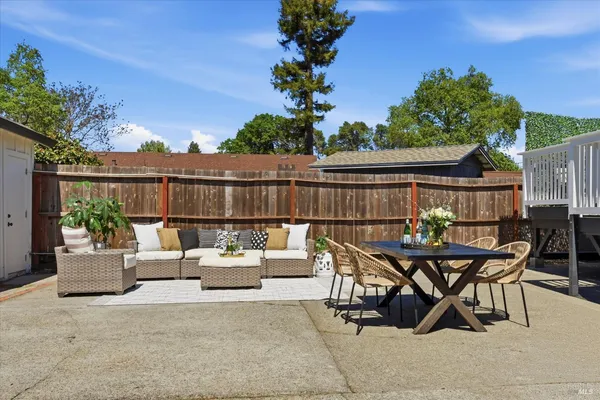 a view of a patio with furniture and a garden