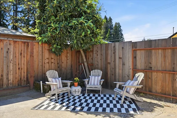 an outdoor sitting area with furniture and wooden fence