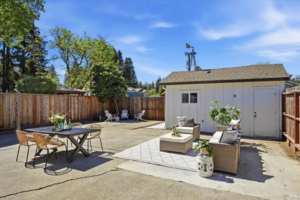 a backyard of a house with table and chairs